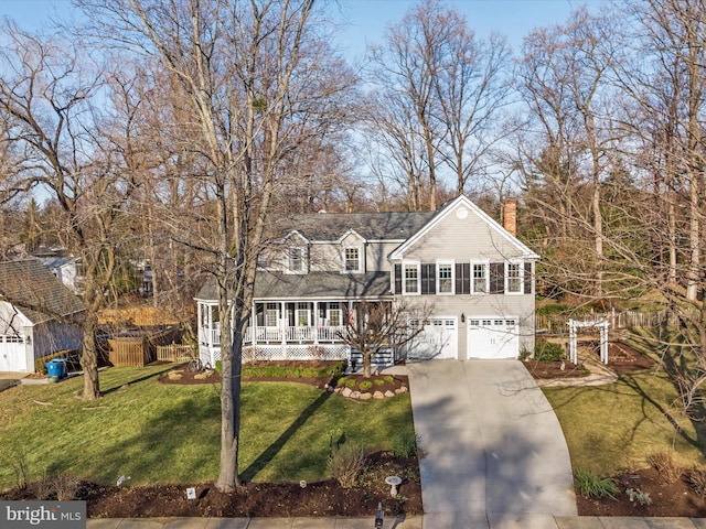 view of front of house featuring a garage, covered porch, and a front lawn