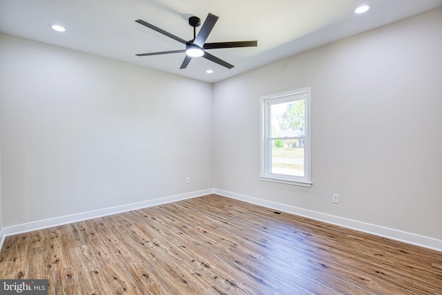 unfurnished room featuring wood finished floors, baseboards, visible vents, and recessed lighting
