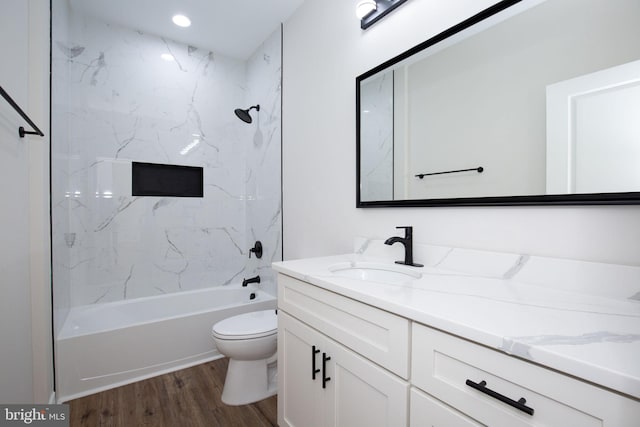 full bathroom with toilet, wood finished floors, vanity, and shower / tub combination