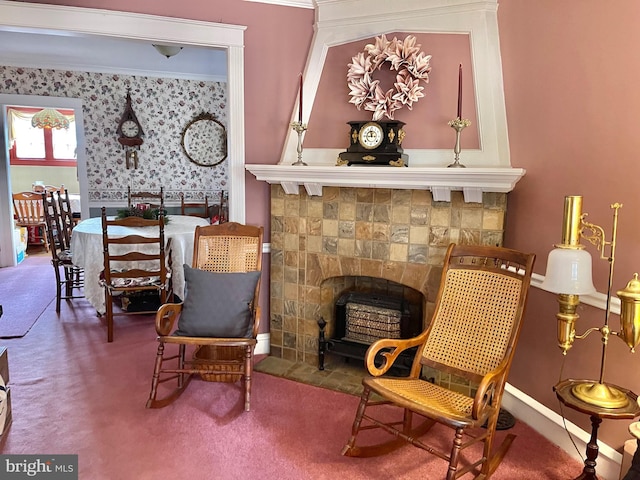 living area with carpet floors, ornamental molding, and a tiled fireplace