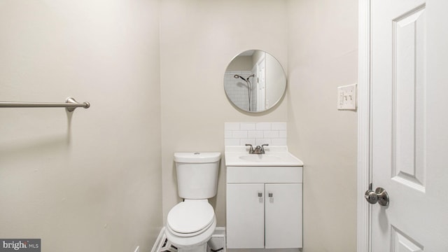 bathroom featuring decorative backsplash, vanity, baseboards, and toilet