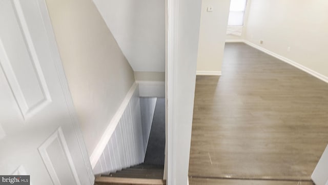 staircase with baseboards and wood finished floors