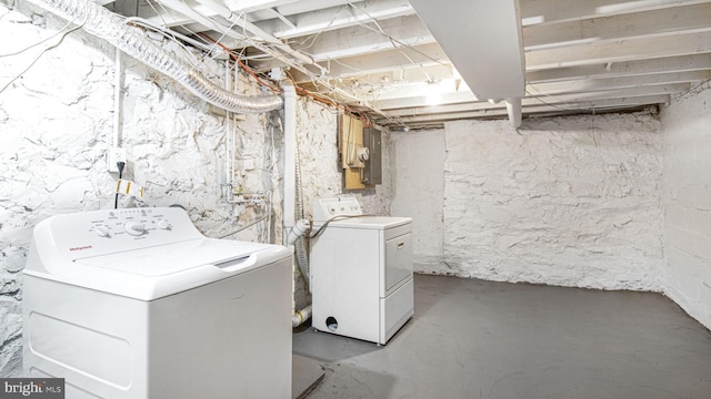 unfinished below grade area featuring electric panel and independent washer and dryer