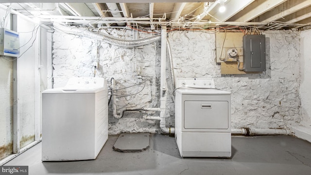 unfinished below grade area featuring electric panel and washer and clothes dryer