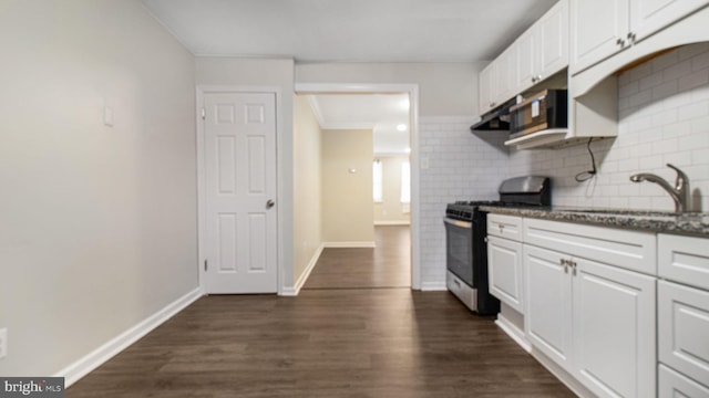 kitchen with white cabinets, decorative backsplash, dark wood finished floors, stainless steel appliances, and a sink