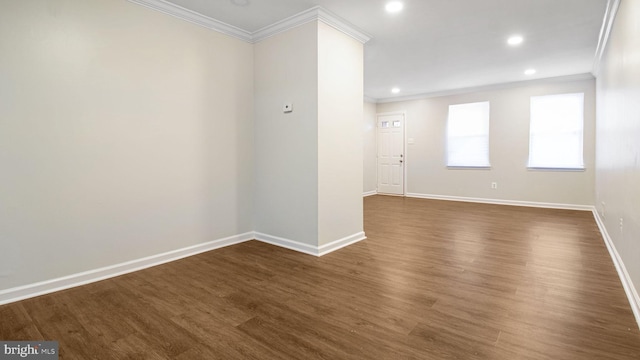 spare room featuring crown molding, baseboards, dark wood-style flooring, and recessed lighting