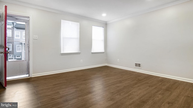 unfurnished room with baseboards, visible vents, dark wood-style flooring, and ornamental molding