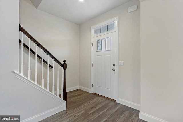 entrance foyer with stairway, wood finished floors, and baseboards