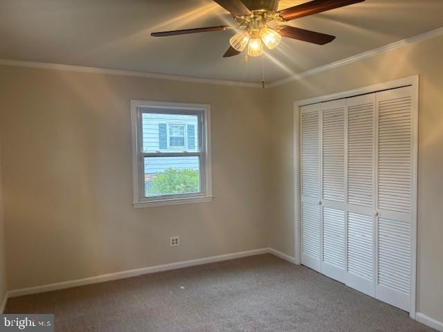 unfurnished bedroom with carpet, a closet, crown molding, and baseboards