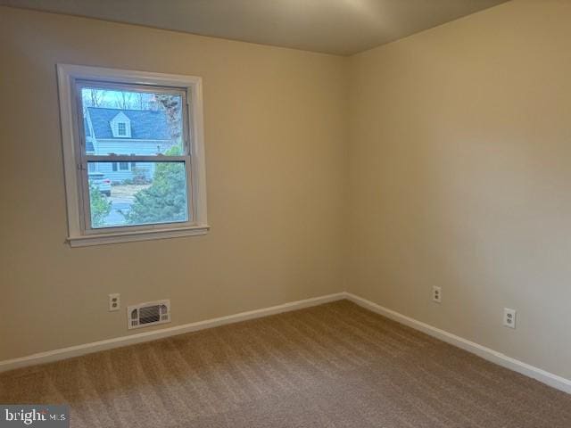 carpeted spare room featuring visible vents and baseboards