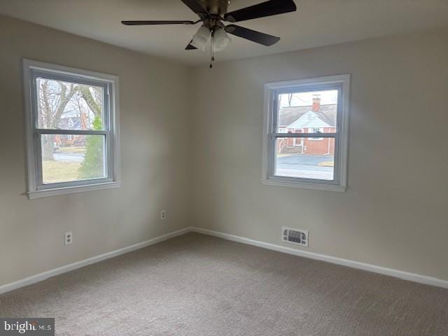 unfurnished room featuring a ceiling fan, carpet, visible vents, and baseboards