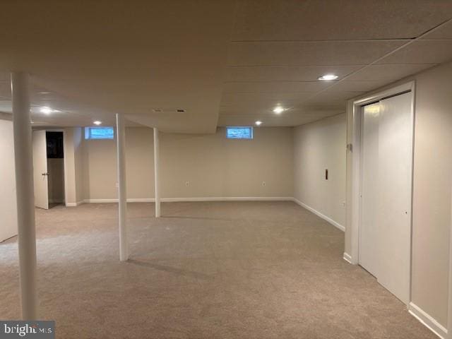 basement with light carpet and baseboards