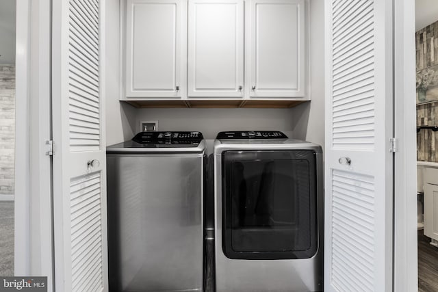 laundry room featuring independent washer and dryer, dark hardwood / wood-style floors, and cabinets