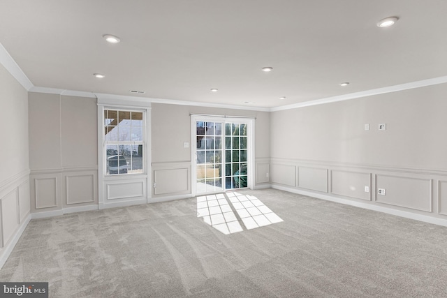 carpeted empty room featuring crown molding