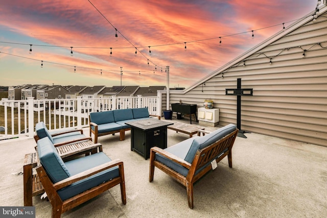 patio terrace at dusk featuring an outdoor living space with a fire pit