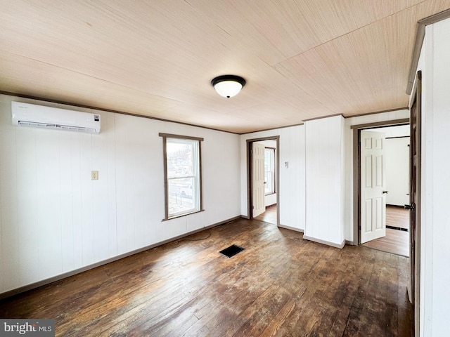 interior space featuring baseboards, visible vents, a wall unit AC, dark wood-style flooring, and crown molding