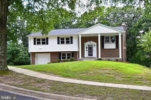 split foyer home featuring a garage and a front lawn