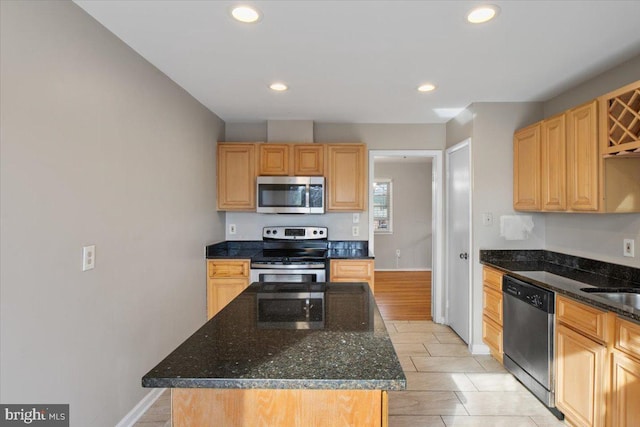 kitchen featuring stainless steel appliances, a center island, dark stone counters, and recessed lighting