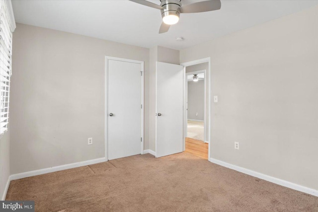 unfurnished bedroom with light carpet, ceiling fan, and baseboards