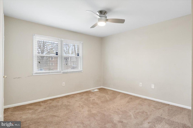 spare room with light carpet, baseboards, and visible vents