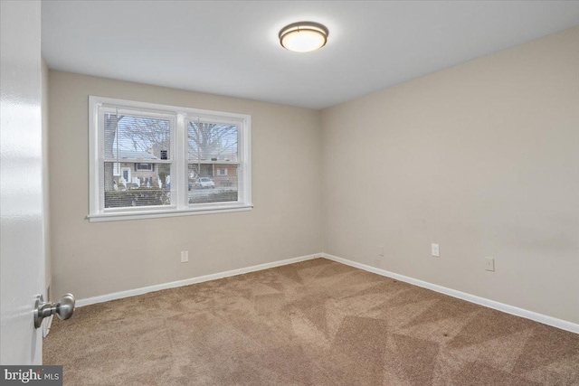 unfurnished room with light carpet and baseboards