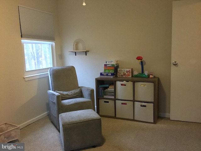 living area with baseboards and light colored carpet