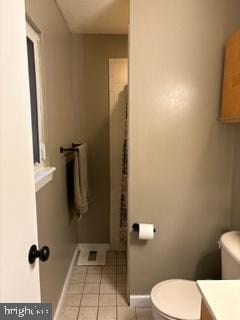 bathroom featuring baseboards, vanity, toilet, and tile patterned floors