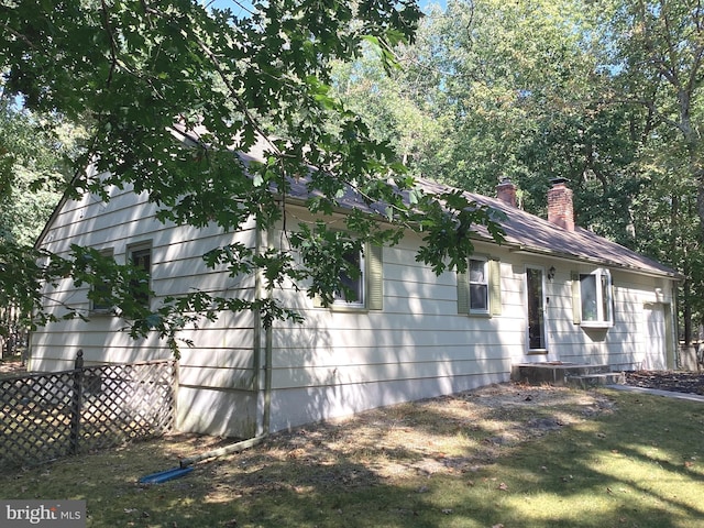 view of front facade featuring fence, a front lawn, and a chimney