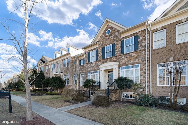 multi unit property featuring stone siding and a residential view