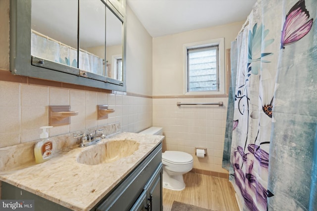 bathroom with toilet, hardwood / wood-style flooring, tile walls, and vanity