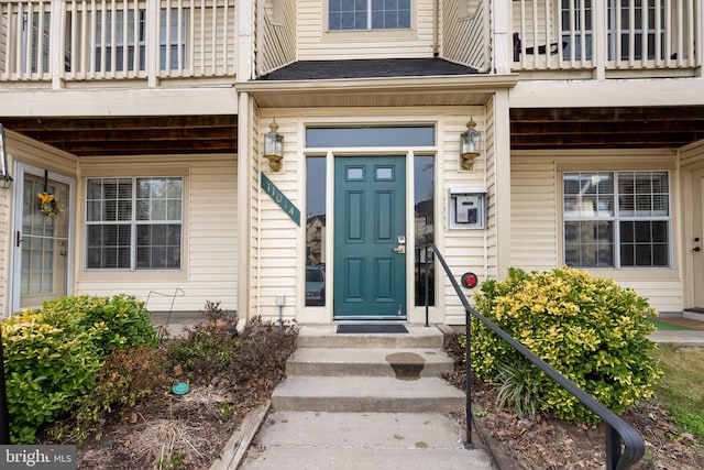 doorway to property featuring roof with shingles