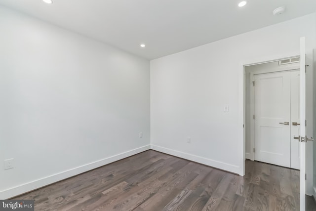 unfurnished room with dark wood-type flooring