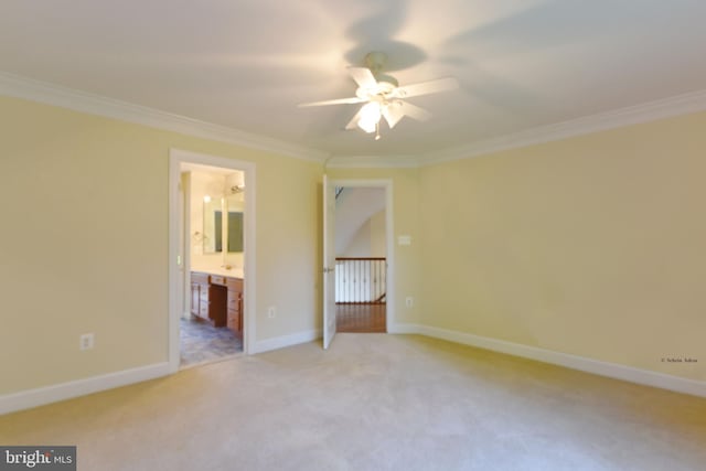 unfurnished bedroom featuring ensuite bathroom, crown molding, and light colored carpet