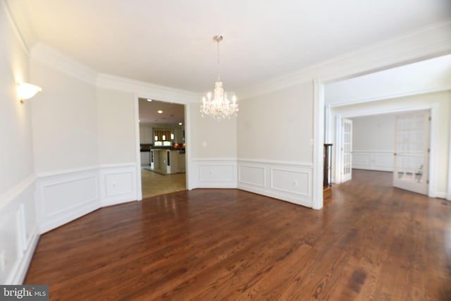 unfurnished dining area featuring a chandelier, crown molding, and dark hardwood / wood-style floors