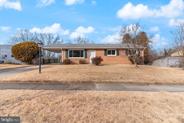 ranch-style home with a front yard and a carport