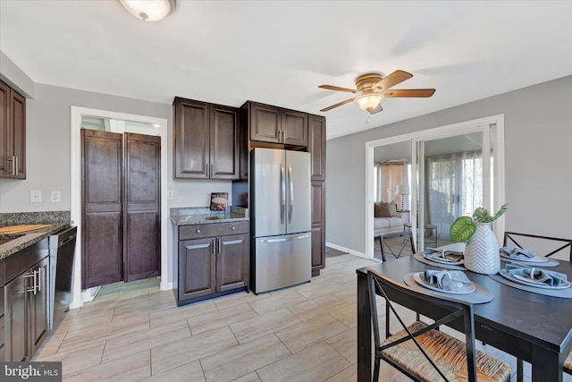 kitchen with dark brown cabinetry, dishwasher, and freestanding refrigerator