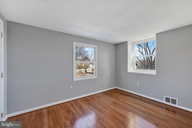 unfurnished bedroom featuring baseboards, visible vents, and wood finished floors