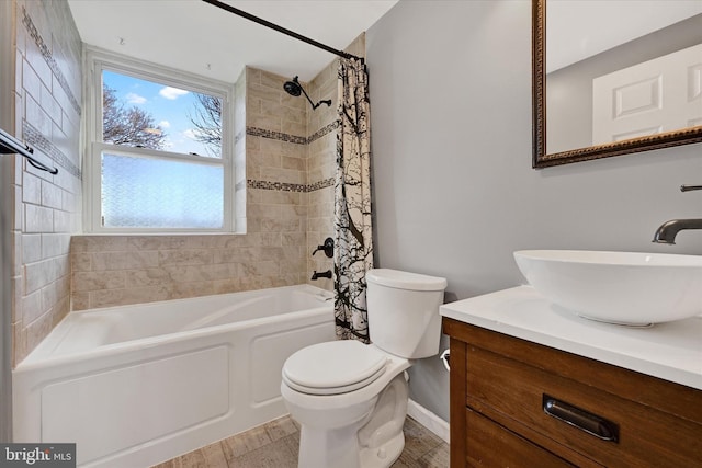 bathroom featuring shower / bath combo with shower curtain, vanity, toilet, and baseboards