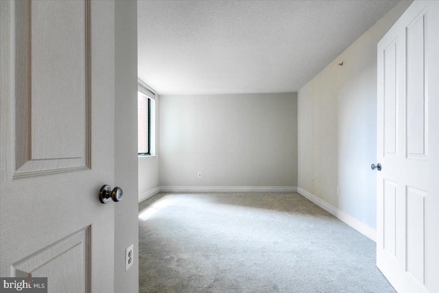 bonus room featuring baseboards, a textured ceiling, and light colored carpet