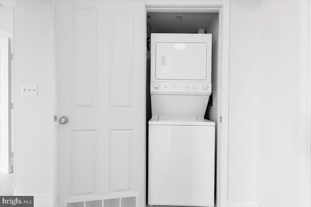 laundry area featuring stacked washer and dryer, laundry area, and visible vents