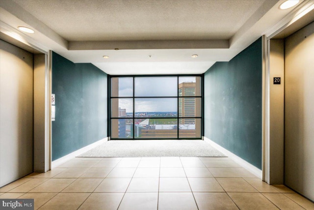 unfurnished room featuring light tile patterned floors, floor to ceiling windows, baseboards, and elevator