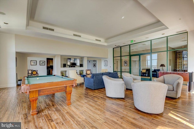 game room featuring visible vents, a tray ceiling, wood finished floors, and pool table