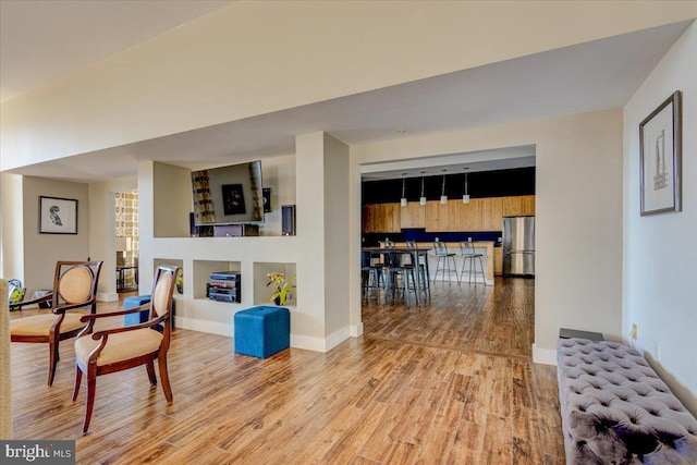 living area featuring baseboards and wood finished floors