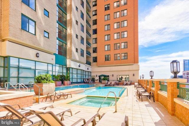 community pool featuring a hot tub and a patio