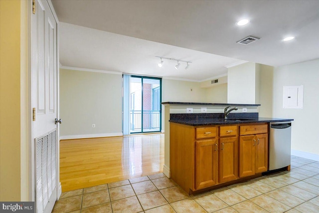 kitchen with crown molding, visible vents, stainless steel dishwasher, brown cabinetry, and dark stone counters