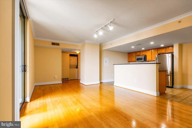 unfurnished living room with light wood finished floors, ornamental molding, visible vents, and baseboards