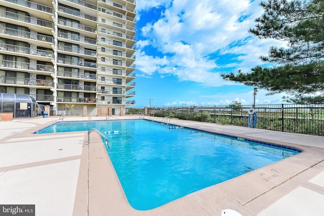 community pool featuring a patio and fence