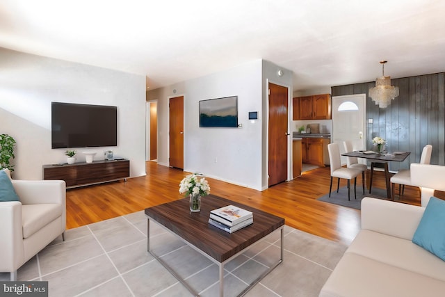 living room with light wood-type flooring and an inviting chandelier