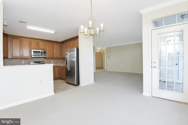 kitchen featuring appliances with stainless steel finishes, a chandelier, decorative light fixtures, crown molding, and light carpet