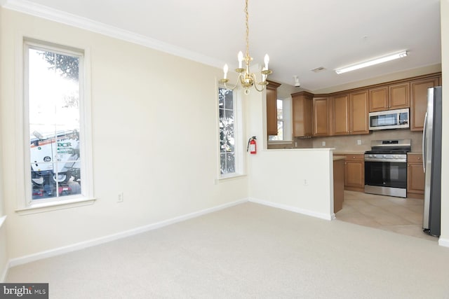 kitchen with an inviting chandelier, appliances with stainless steel finishes, ornamental molding, pendant lighting, and light colored carpet